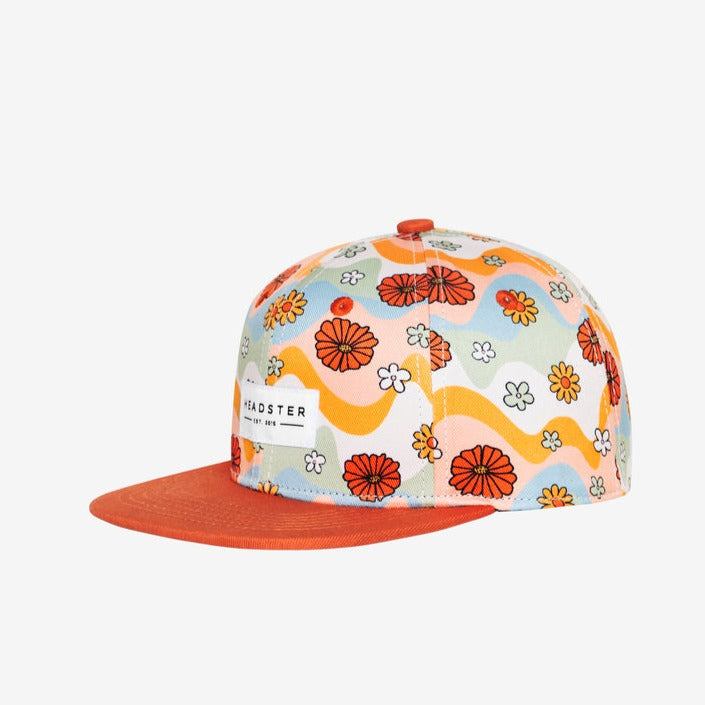 Flower Patch Squash Snapback by Headster white background and surface. 