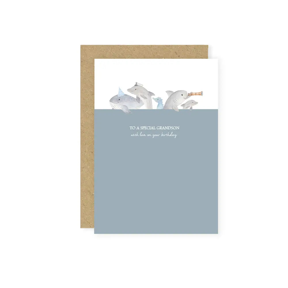 White background with a Kraft envelope and a 'To A Special Grandson...' Card by Little Roglets. Card is portrait style with a medium blue colourblock on 3/4 of the card, and some sea animals on top, and the text says "To a special grandson with love on your birthday."