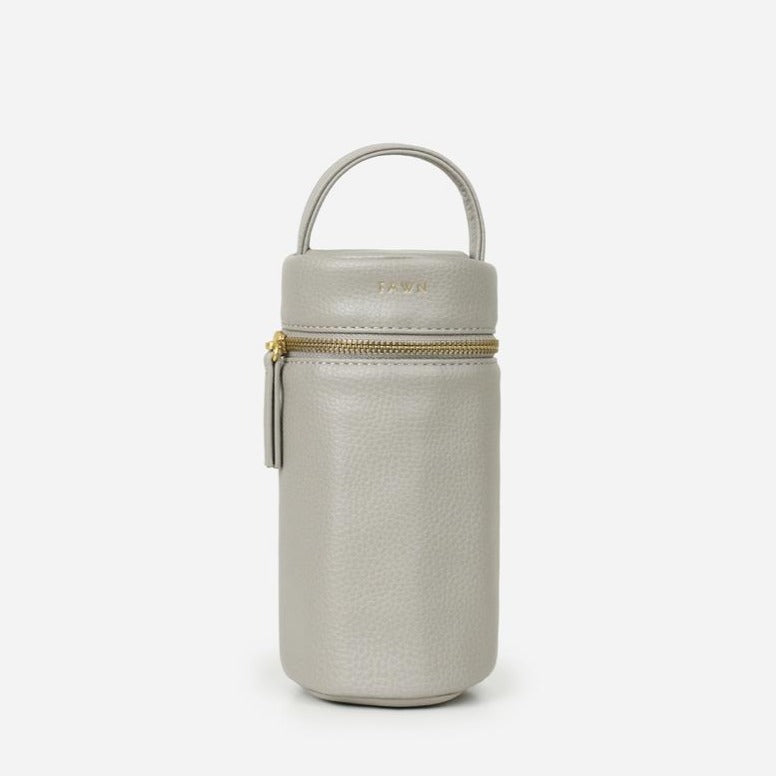 White background with The Bottle Bag in Grey by Fawn Design. Bottle is round, and has the words "FAWN' in gold lettering around the top.