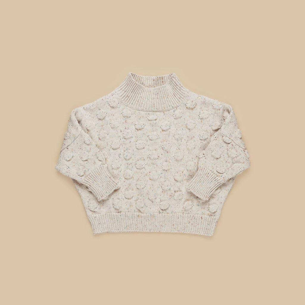 Beige background with Sprinkles Knit Jumper by Hux Baby. Jumper is a multi-colour bobble knit.