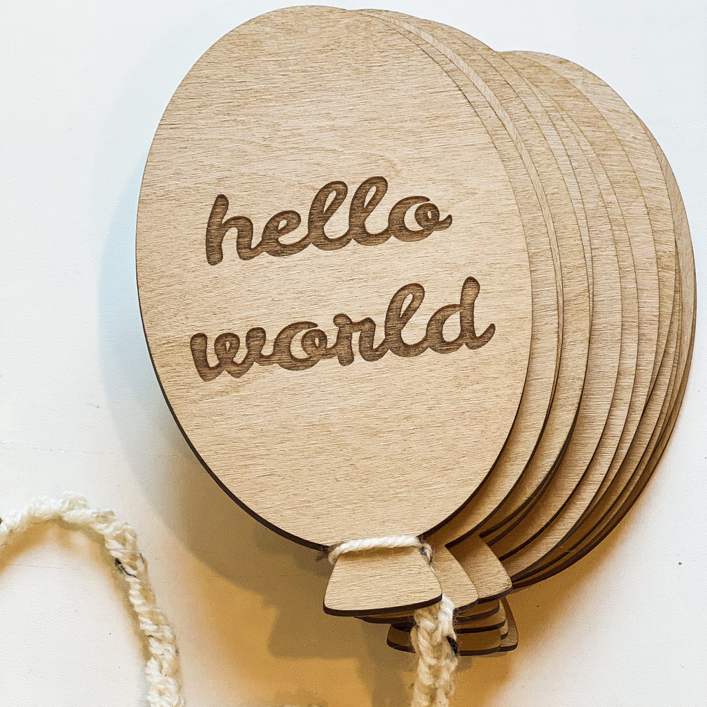 White background with the Hello World Balloon Milestone Set in Wheat by Petit Nordique. This is showing the colour, which is a yellow/cream colour.