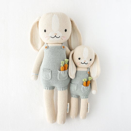 White background with Henry The Bunny by Cuddle and Kind, both sizes laying side by side.