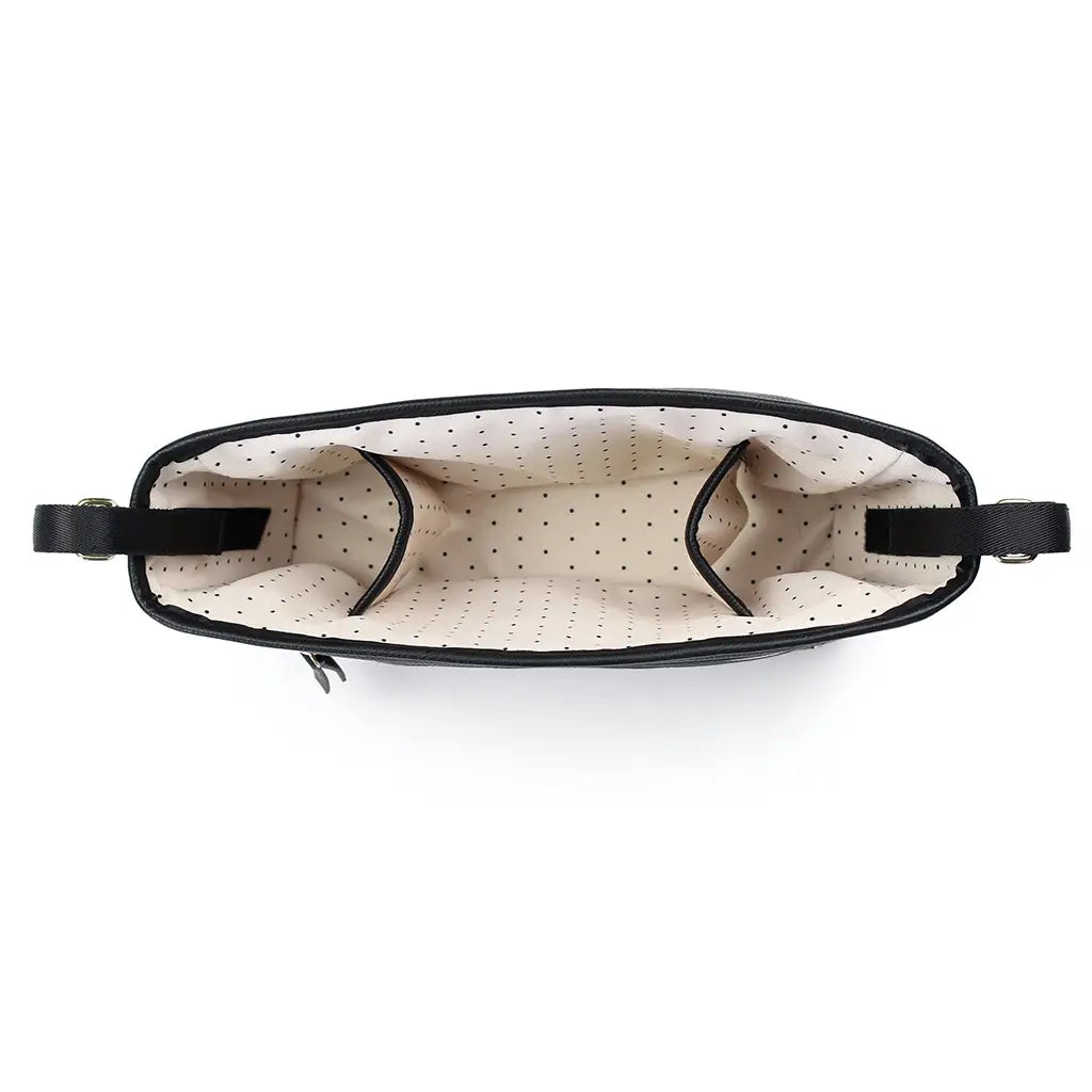 White background with overhead view of the Jetsetter Black travel Stroller Caddy by Itzy Ritzy. This shows the inside of the stroller caddy which is a cream colour with black dots.