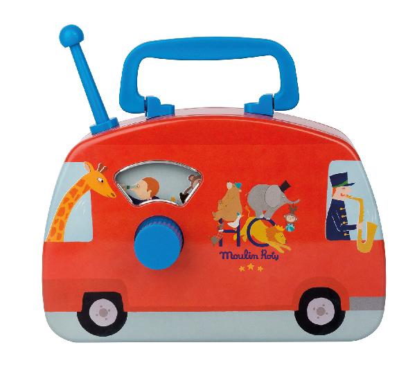White background with Les Jouets Metal - Musical Circus Bus by Moulin Roty. The bus is deep red, with a bright blue handle, it's metal and plays music.