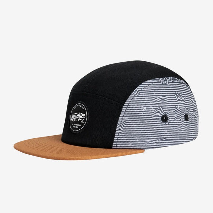 Lineup Five Panel Black by Headster with white background and surface. 