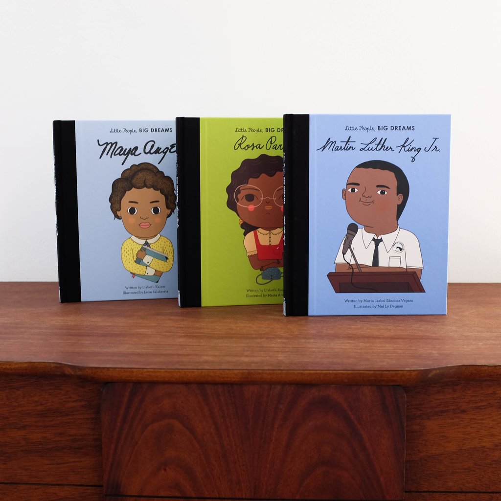 White background with a natural wood table, and 3 books from Little People, Big Dreams: Black Voices Gift Set.