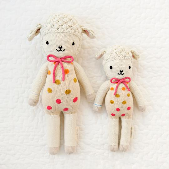 White quilted background with Lucy The Lamb by Cuddle and Kind, both sizes laying side by side.