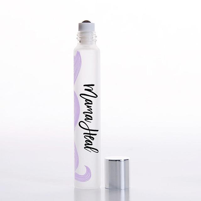 White background with rollerball of Mama Heal Essential Oil Blend by Jane + Thunder.