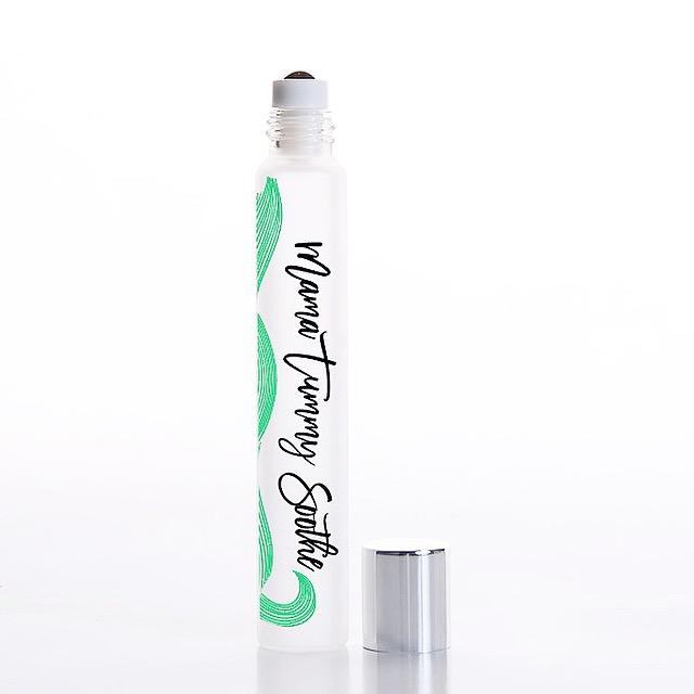White background with rollerball of Mama Tummy Soothe Essential Oil Blend by Jane + Thunder.