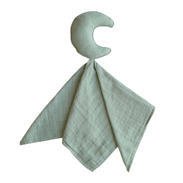 White background with Lovey in Moon/Roman Green by Mushie. Lovey has a stuffed moon with a muslin blanket attached in a eucalyptus green colour.