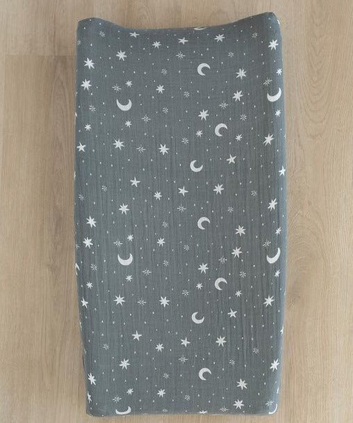 Overhead view of Night Sky Changing Pad Cover by Mebie Baby on a changing pad. Cover is a medium cool blue, with white stars and moons all over.