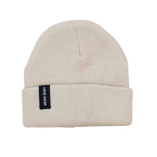 White background with Oatmeal Beanie by Mebie Baby. Beanie is a cream colour with a cuff and a black rectangular tag that says "Mebie Baby" in white.