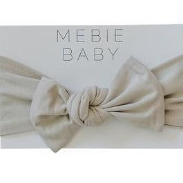 White background with the packaging of the Oatmeal Head Wrap by Mebie Baby.