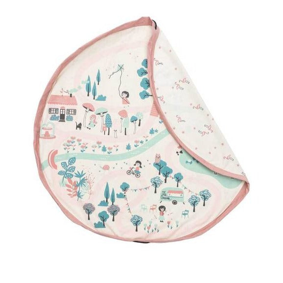 White background with Walk In The Park Playmat & Storage Bag by Play & Go. One side is a creamy pink colour and looks like a park scene, and the other side is flamingos.