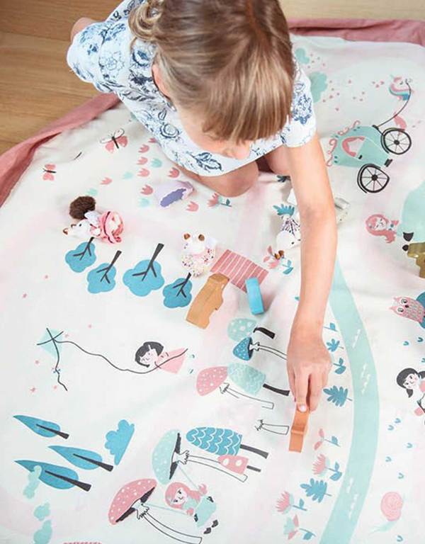 Overhead view of a little girl playing with the Walk In The Park Playmat & Storage Bag by Play & Go.