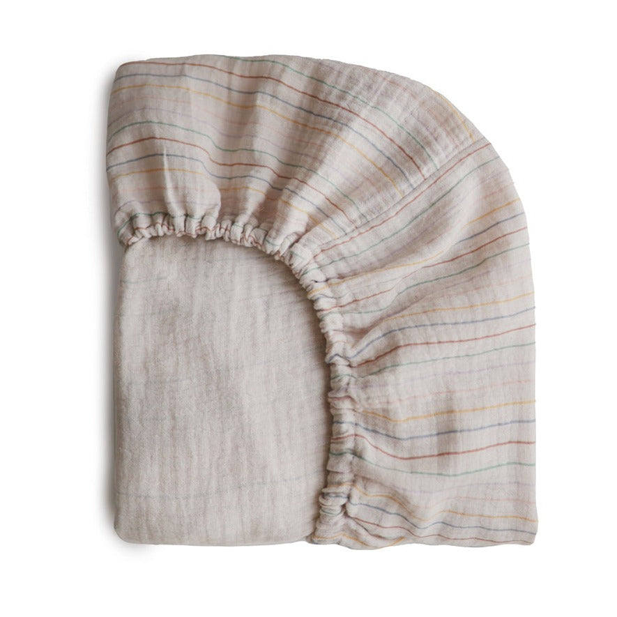 Extra Soft Muslin Crib Sheet in Retro Stripe by Mushie folded, white background. 