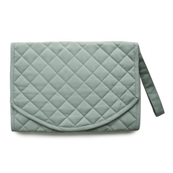 White background with the Portable Changing Pad in Roman Green by Mushie. Changing pad is quilted with a strap, and is a blue/green colour.