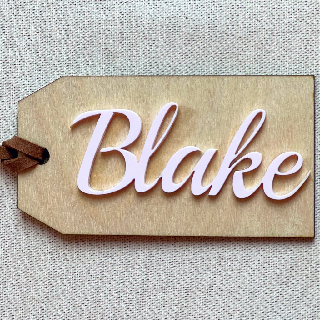 Customized name tag in Rosette with the name Blake on a beige surface. 