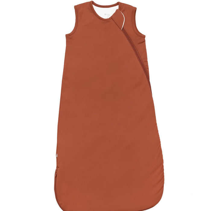 Rust sleep bag/sac by Kyte Baby, with a white back drop. 