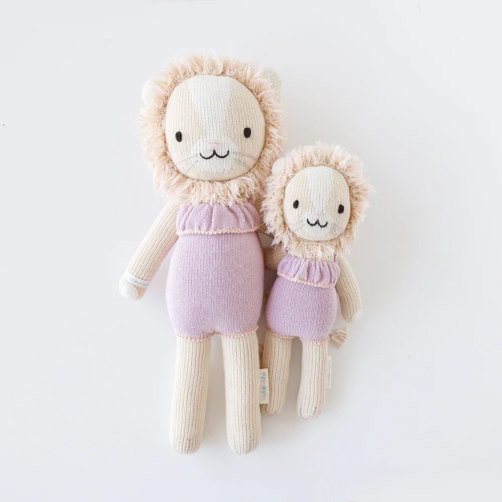White background with Savannah The Lion by Cuddle and Kind, both sizes laying side by side.