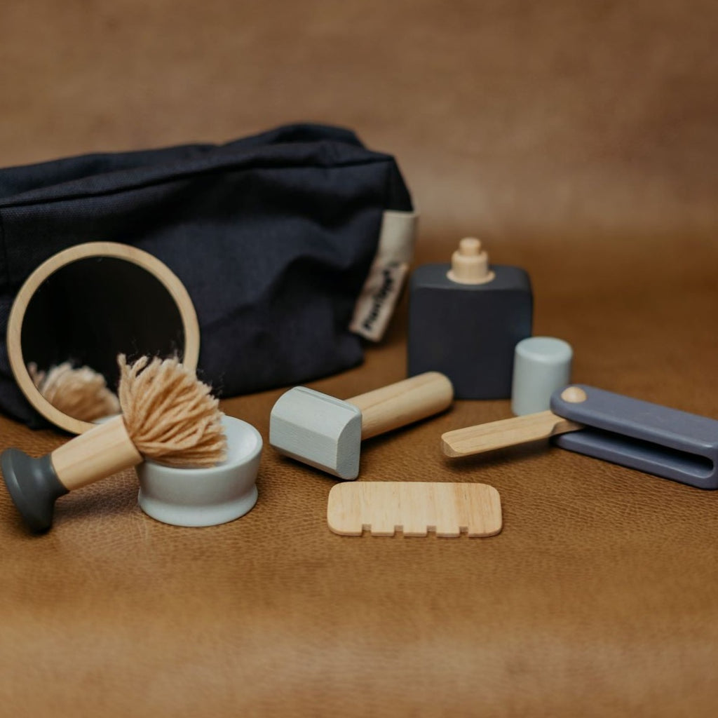 Brown background with Wooden Shave Set by PlanToys. Showing all of the items.