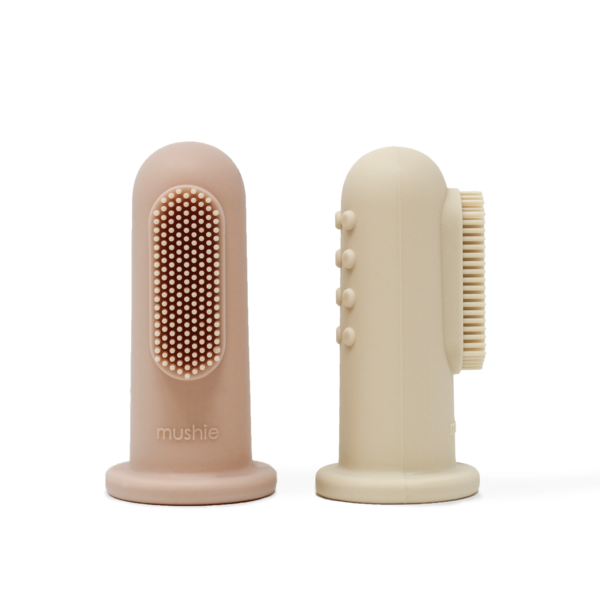 White background with Finger Toothbrush in Blush & Shifting Sand by Mushie. This comes with 2 finger toothbrushes, 1 is a blush colour, and the other is beige.