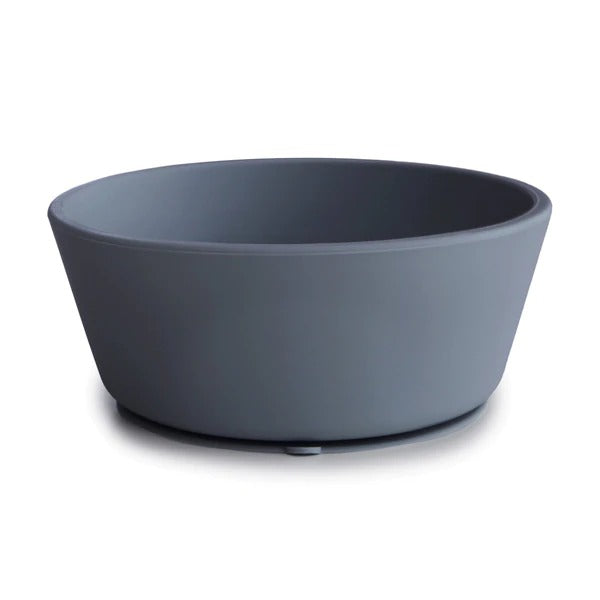 White background with Silicone Suction Bowl in Tradewinds by Mushie. Bowl has a suction base, and is a deep blue grey colour.