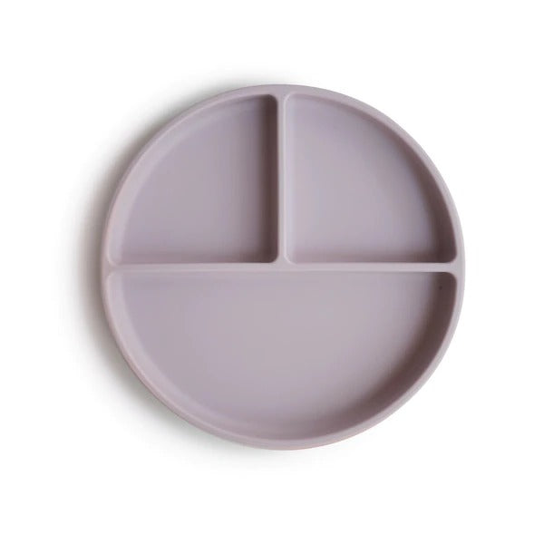 White background with a Silicone Suction Plate in Soft Lilac by Mushie. Plate is rounded with 3 compartments, 2 smaller, and 1 larger, in a pale purple colour.