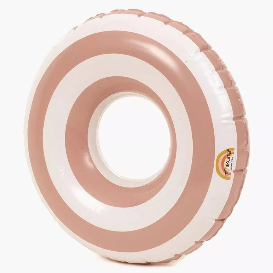 White background with Swim Ring for Dolls in Blush by Minikane. Swim ring is a white and blush stripe.