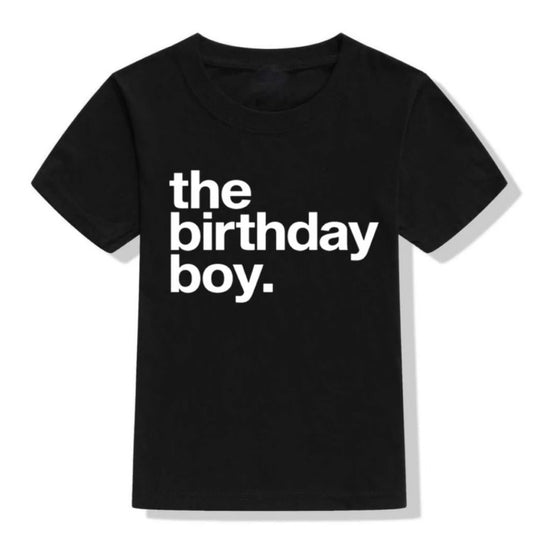 White background with The Birthday Boy Black T-Shirt by Tiny Trendsetters. T-Shirt is black, and says "the birthday boy." in white.