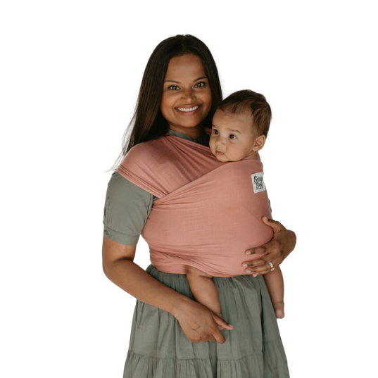 Woman wearing baby, smiling; wrap is rose coloured by Beluga Baby