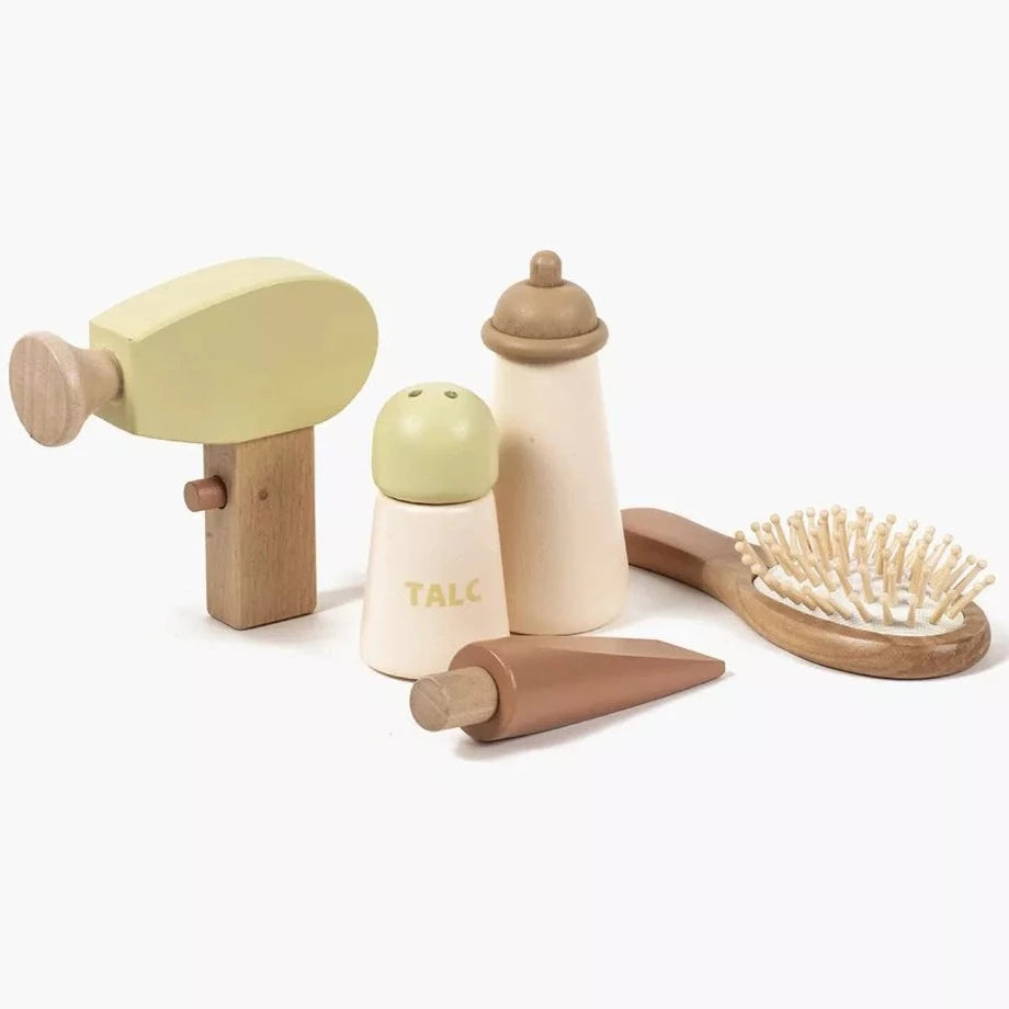 White background with Wooden Toiletry Set For Dolls by Minkane. Set shows a hair dryer, talc container, bottle, tube, and a brush.