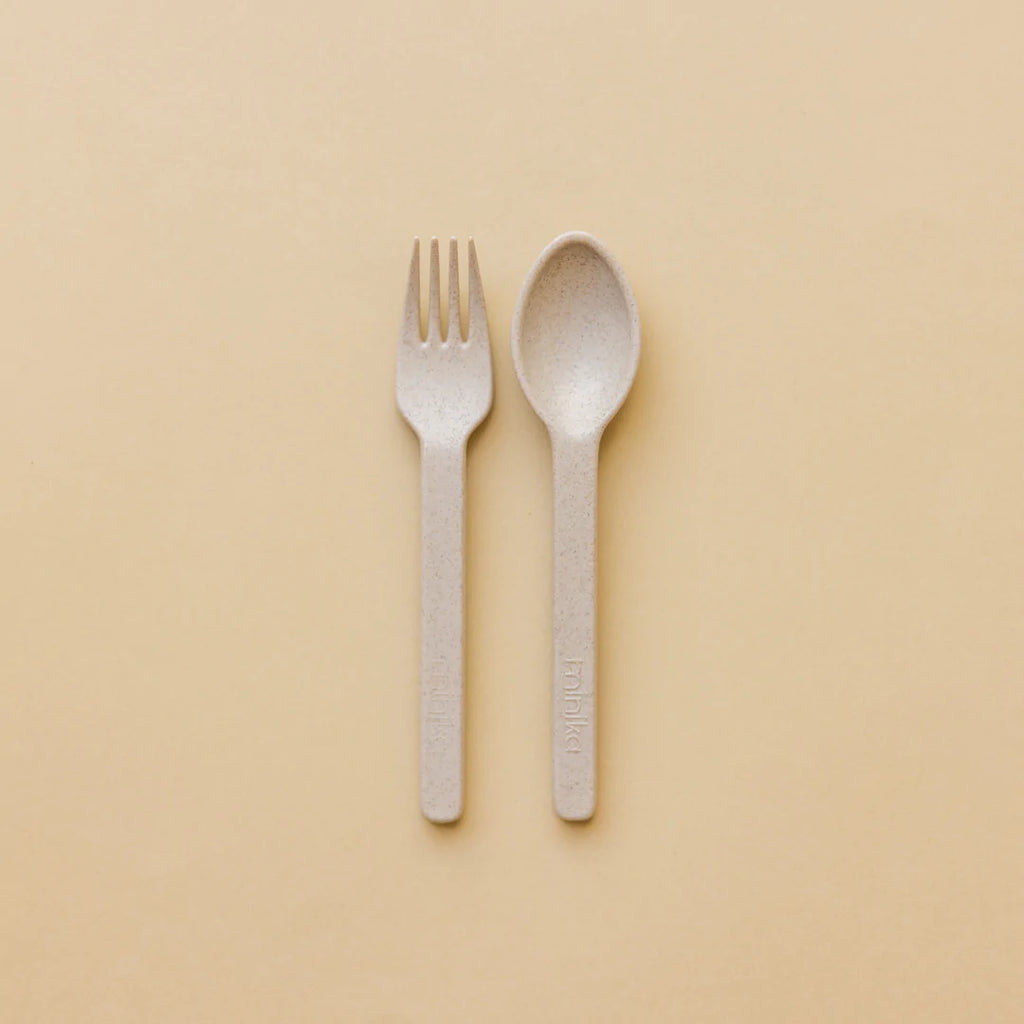 Beige background with the Wheat Straw Utensil Set in Shell by Minika. Set includes a fork and spoon, in a shell/oat colour.