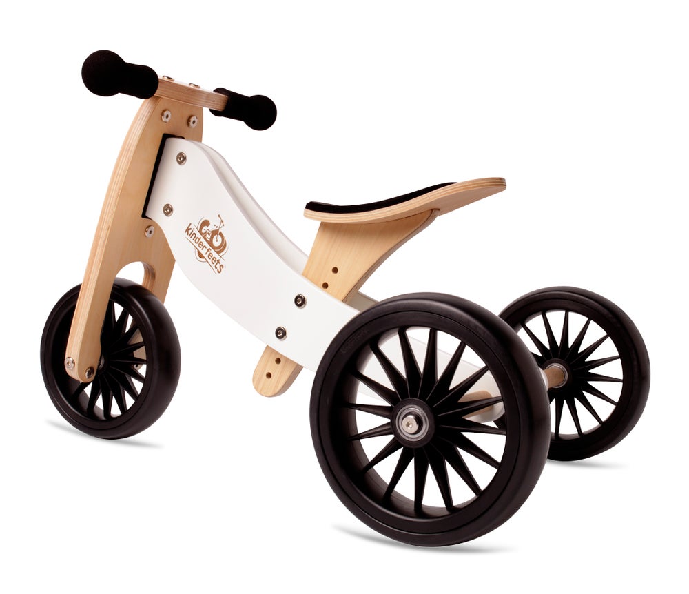 White background with Tiny Tot Plus Balance Bike in White by Kinderfeets. Bike is a natural wood, with white details, black tires, black handle bars, and a black seat.