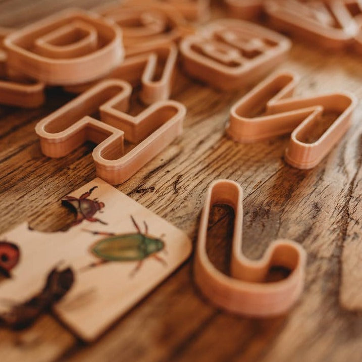 Alphabet Eco Cutter Set by Kinfolk Pantry letters placed on wooden surface