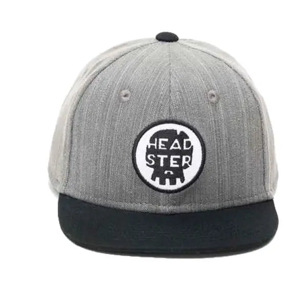 White background with a straight on view of the Dark G-NZ Snapback Hat by Headster. Hat is a dark grey, with black brim, and a patch that says "Headster".