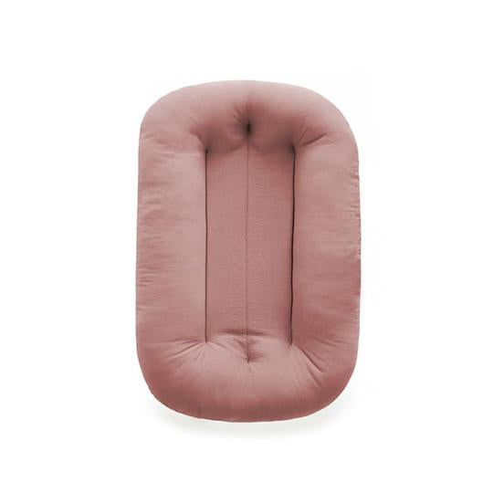 White background with the Snuggle Me Organic Infant Lounger in Gumdrop by Snuggle Me. Lounger is a medium blush pink. 