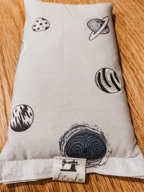 Close up of Children's Soothing Bag in Space by L&L.co. Soothing bag in white with black & grey planets all over.
