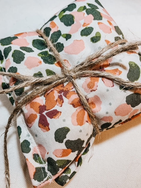 Close up of Boobie Bag in Pink & Green Floral by L&L.co. Boobie bag is white with pink & green watercolour flowers, comes with 2 bags bundled together with twine.