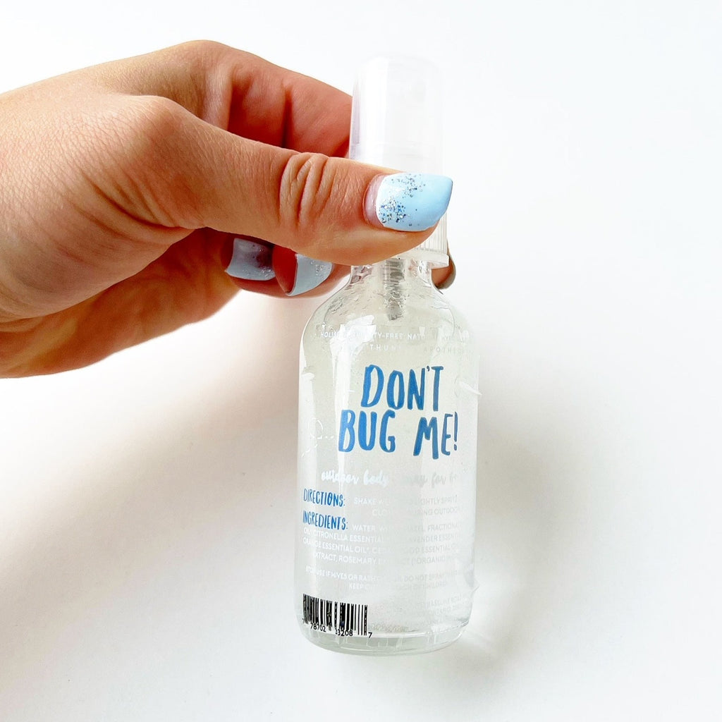 White background with hand holding a bottle of Don't Bug Me! by Jane + Thunder.