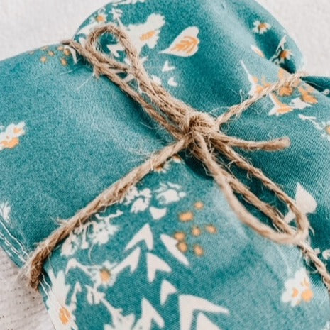 Close up of Boobie Bag in Teal Floral by L&L.co. Boobie bag is teal with flowers, come with 2, and are tied together with twine.