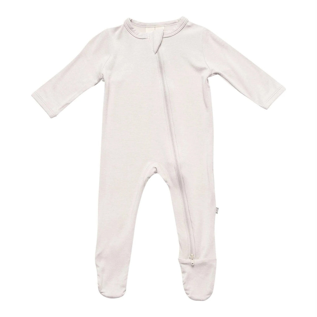 White background with Zippered Footie in Oat by Kyte Baby. Zippered footie is a neutral/grey colour, with a zipper going down the front.