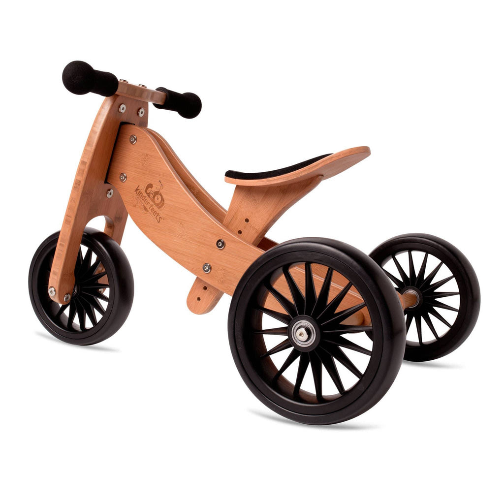 White background with Tiny Tot Plus Balance Bike in Bamboo by Kinderfeets. Bike is a bamboo wood with Black wheels, black handle bars, and a black seat.